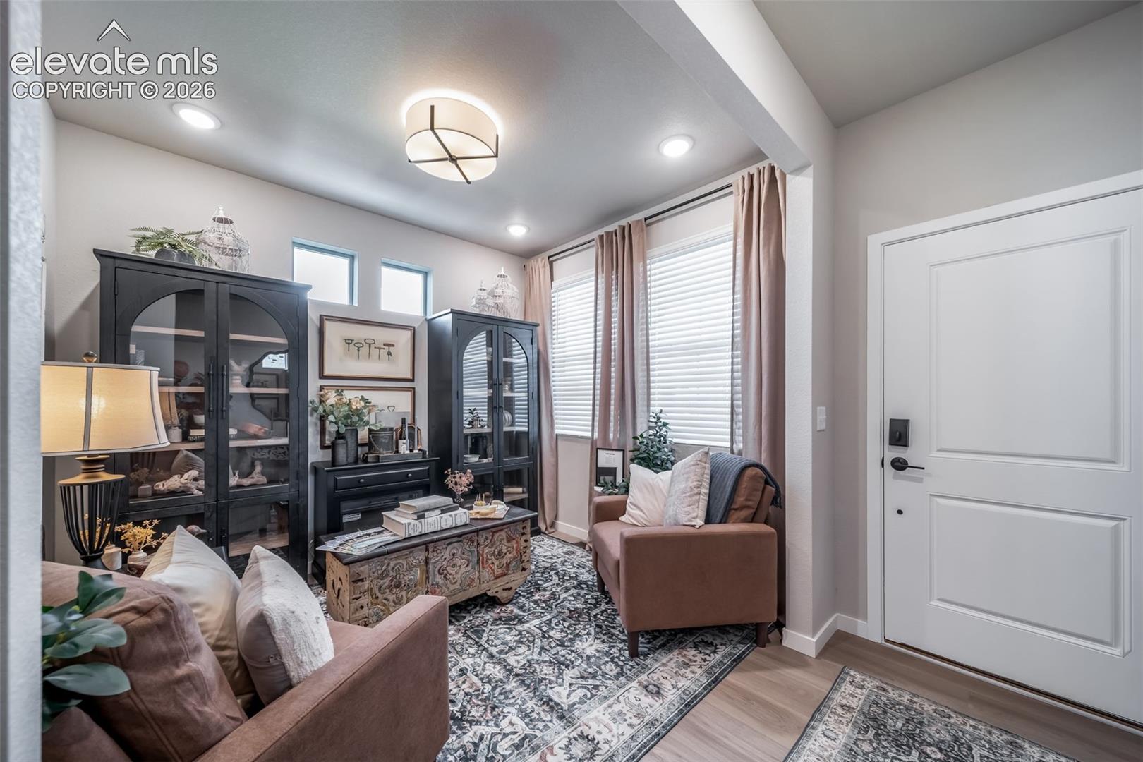 Entryway featuring wood-finish flooring and a paneled door with matte black hardware
*Photos of a model home*