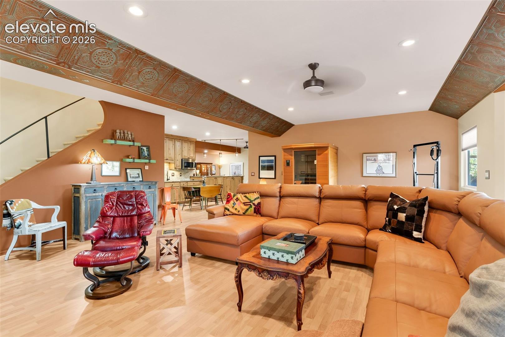 Expansive room featuring ornate metal ceiling panels, wood-finish flooring, recessed lighting, and a ceiling fan
