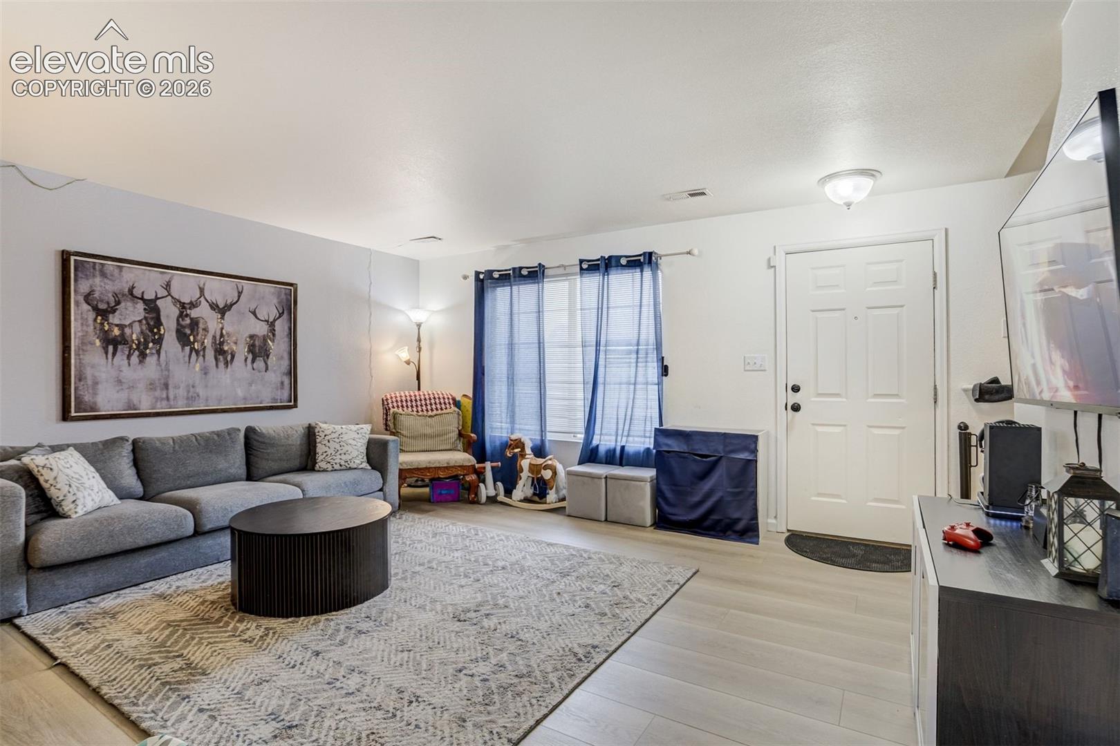 Light-toned flooring throughout, white interior walls, and an overhead flush-mount light fixture