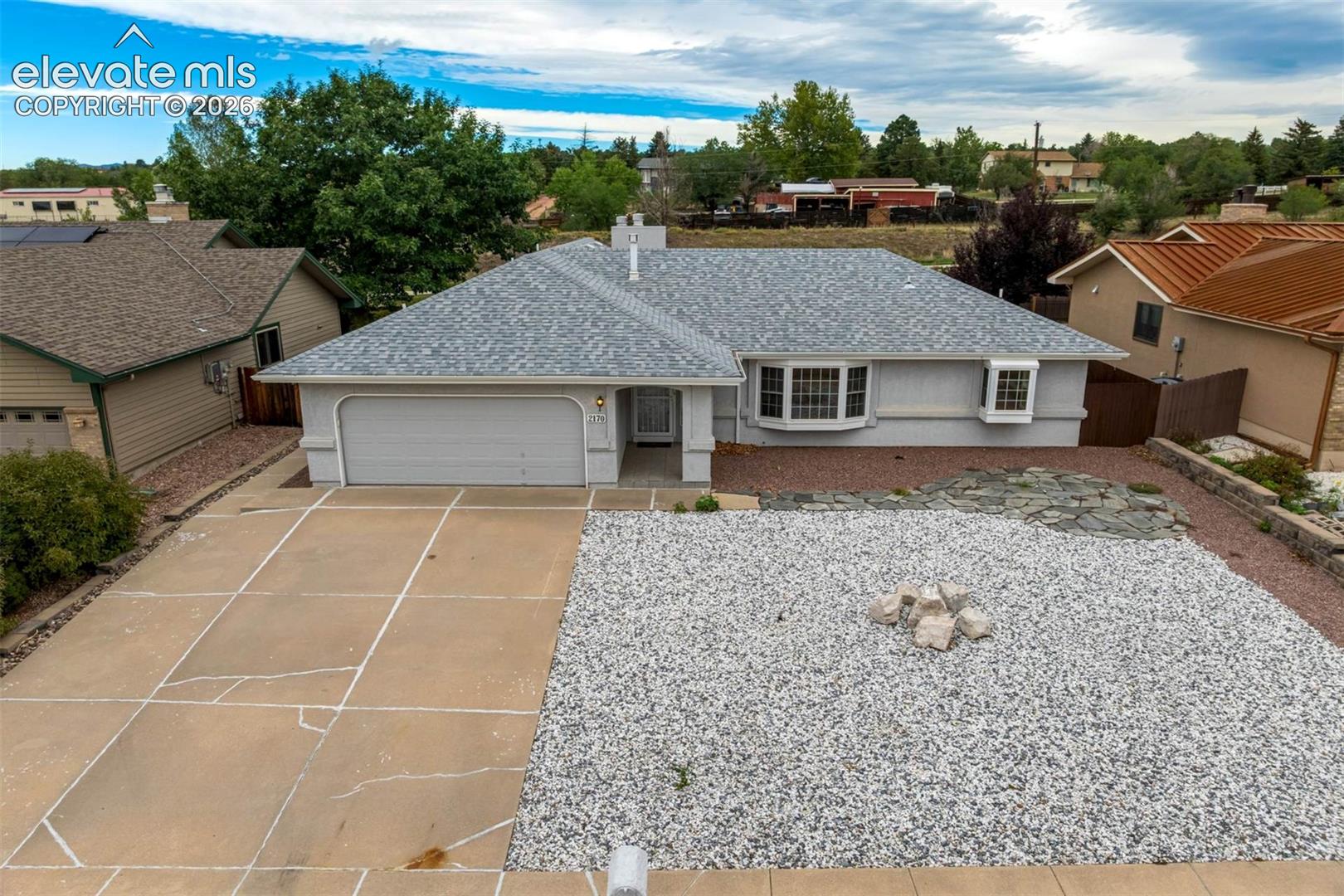 Sprawling stucco ranch-style home offering comfortable main-level living, a spacious two-car garage, and xeriscaped front and back yards. A covered tile entry welcomes you into a bright, open living and dining room combination. An additional family room provides a cozy gathering space with a gas-log fireplace accented by tile and brick.The spacious kitchen features abundant cabinetry and counter space, along with ceramic tile flooring. The primary suite is privately situated in its own area of the home and includes a four-piece bath and walk-in closet with a cedar-lined floor. Two additional bedrooms are located on the opposite side of the home, separated by a full hall bath featuring ceramic tile flooring and a glass tub/shower enclosure.A convenient main-level laundry room is located just off the garage entry. One of the home's highlights is the enclosed sunroom, offering wonderful additional living space for relaxing, reading, dining, or entertaining while enjoying the outdoors protected from the elements.The finished basement expands the living space with a large recreation room, additional bedroom, and three-quarter bath—ideal for guests or entertaining. Additional features include central air conditioning, humidifier, vinyl windows, and an already-installed radon mitigation system.The property backs to a trail system and is conveniently located on the east side of town near shopping, restaurants, Peterson Space Force Base, Schriever Space Force Base, and major employment centers. A great opportunity for anyone looking for primarily main-level living with the bonus of finished basement space for guests and recreation.