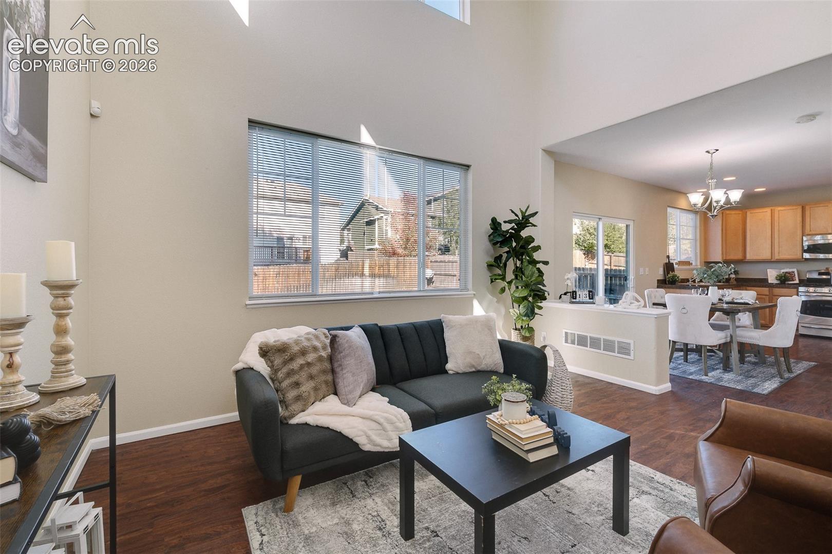 Vaulted ceilings, large picture window, wood-finish flooring, and recessed lighting