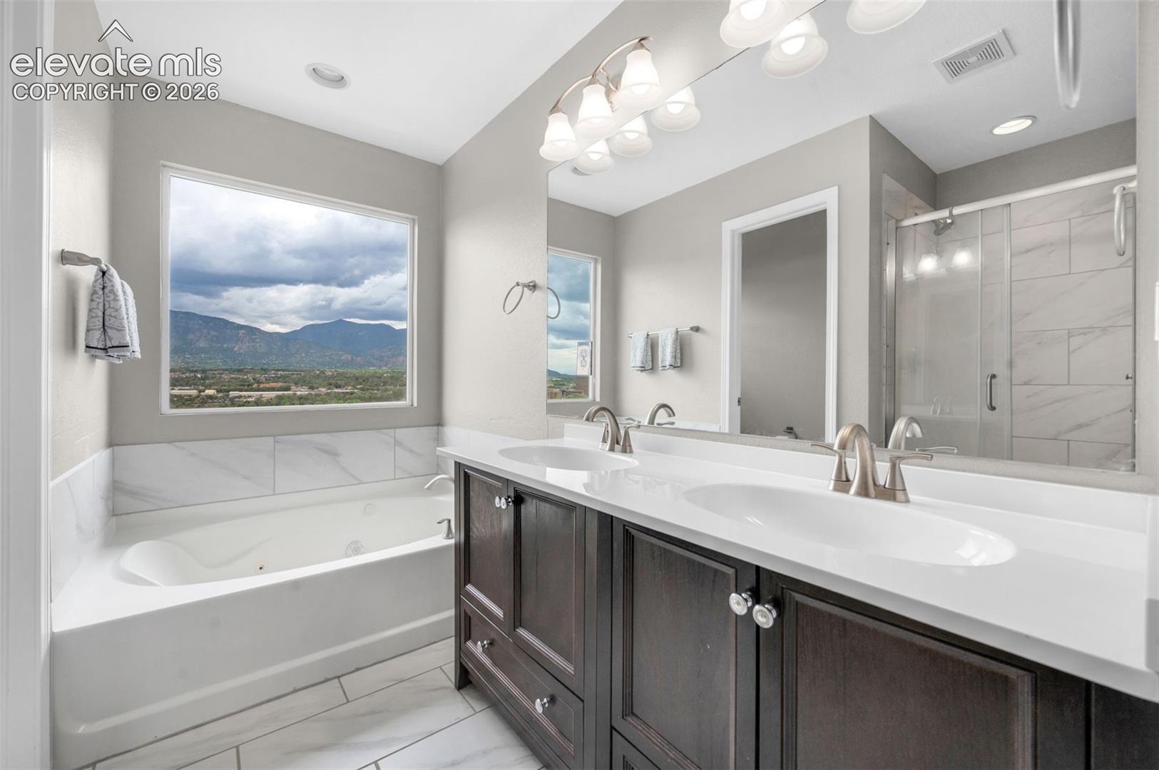 Primary bathroom with a soaking tub, seperate shower, double vanities, and a seperate water closet.