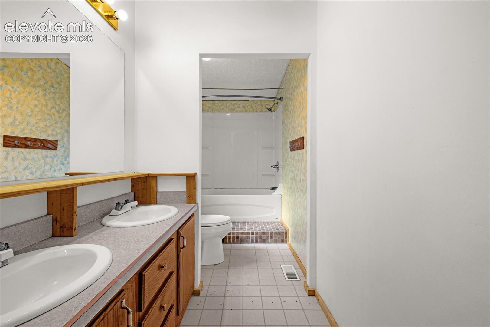 Double vanity with wood-finish cabinetry and integrated sinks