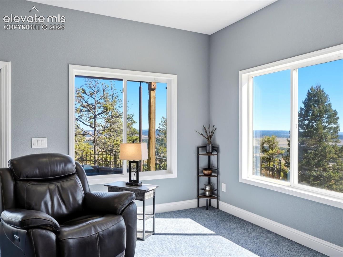 Neutral-toned walls paired with expansive sliding windows featuring exterior woodland scenery and natural light