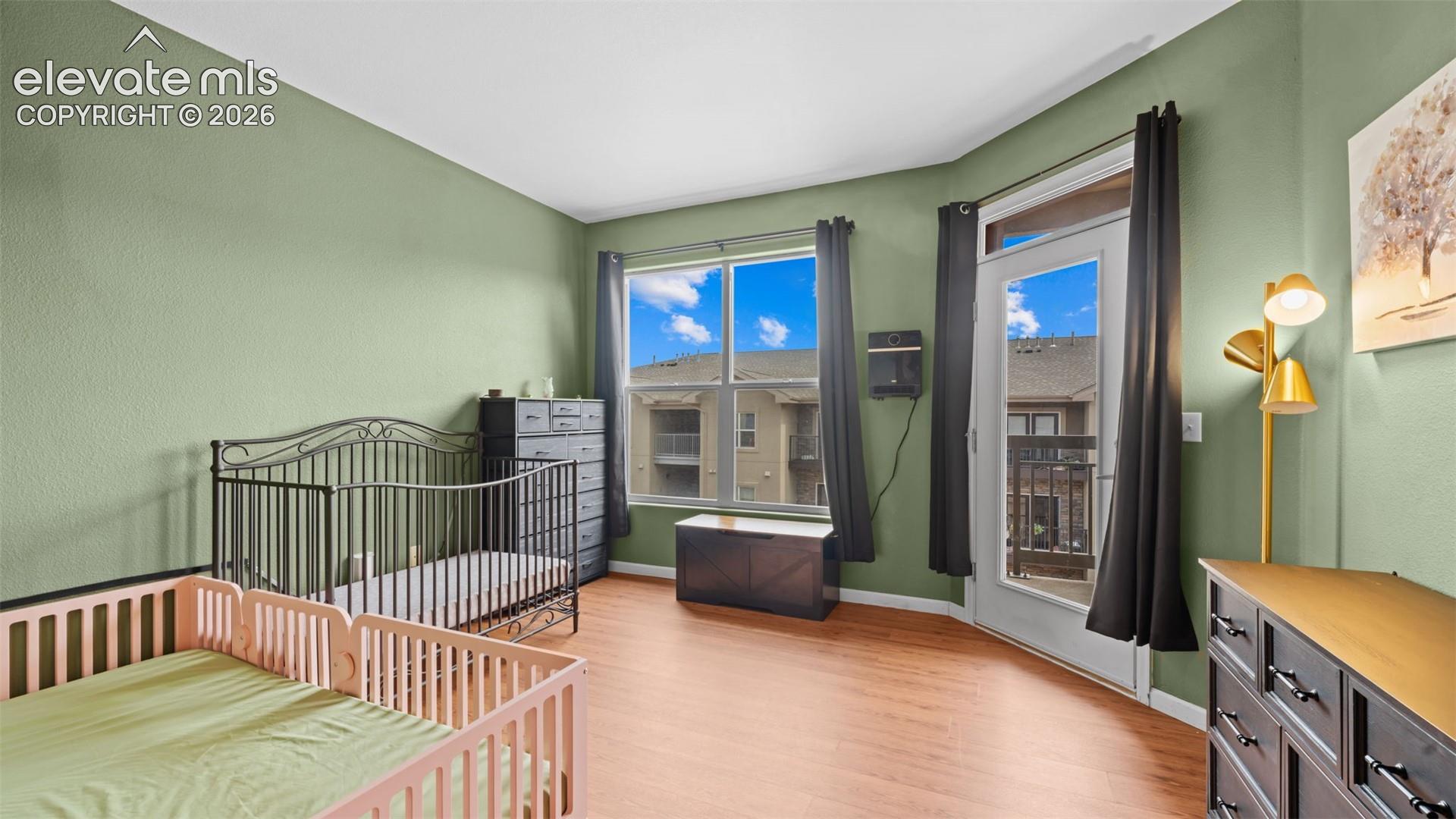 Room featuring light green walls and wood-finish flooring