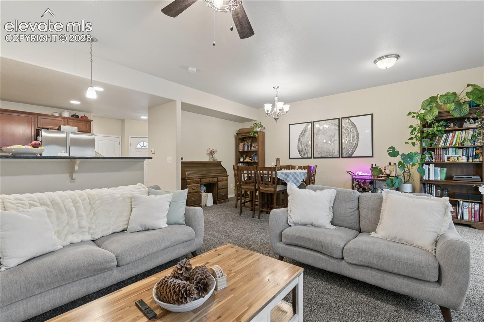 Open-concept living area featuring neutral-toned walls, gray carpeting, a ceiling fan, and recessed lighting