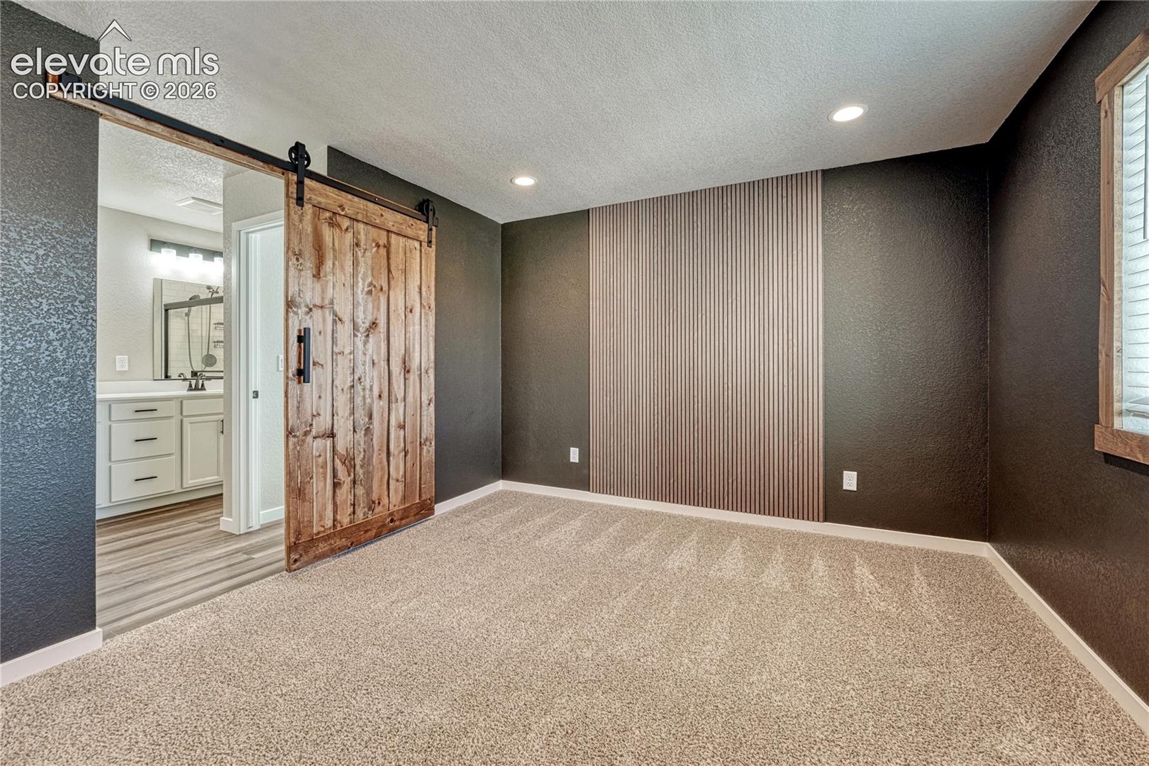 ...and barn door to the adjoining primary bath. 
