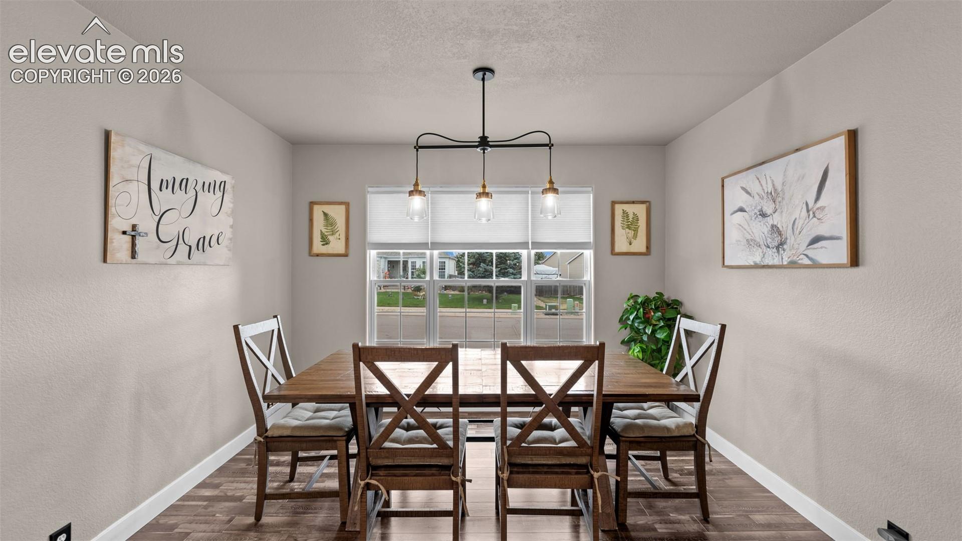 Triple-pendant lighting fixture with matte black finish, wood-finish flooring, and large multi-pane window