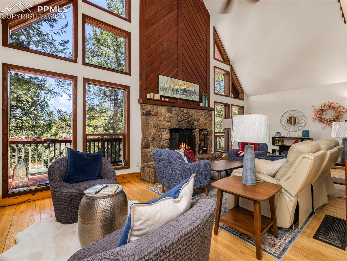 Living room featuring light wood-style floors, vaulted ceiling, and a fireplace