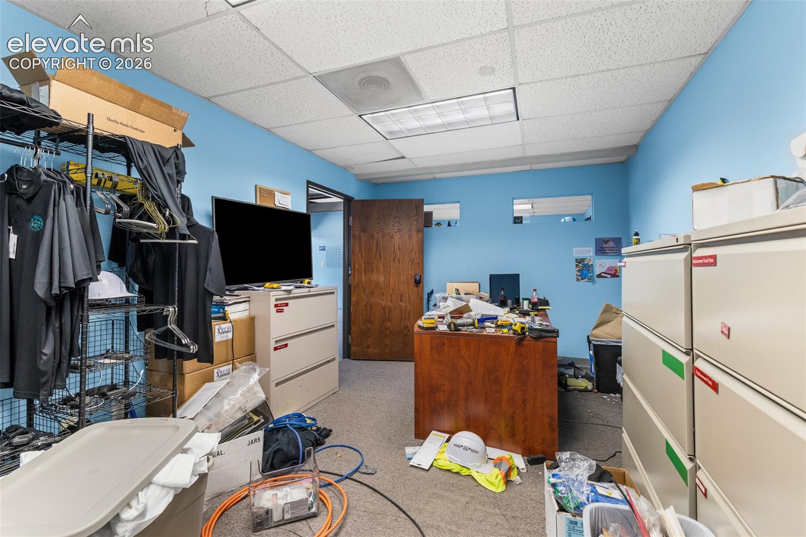 Drop ceiling with recessed fluorescent lighting and carpeted flooring