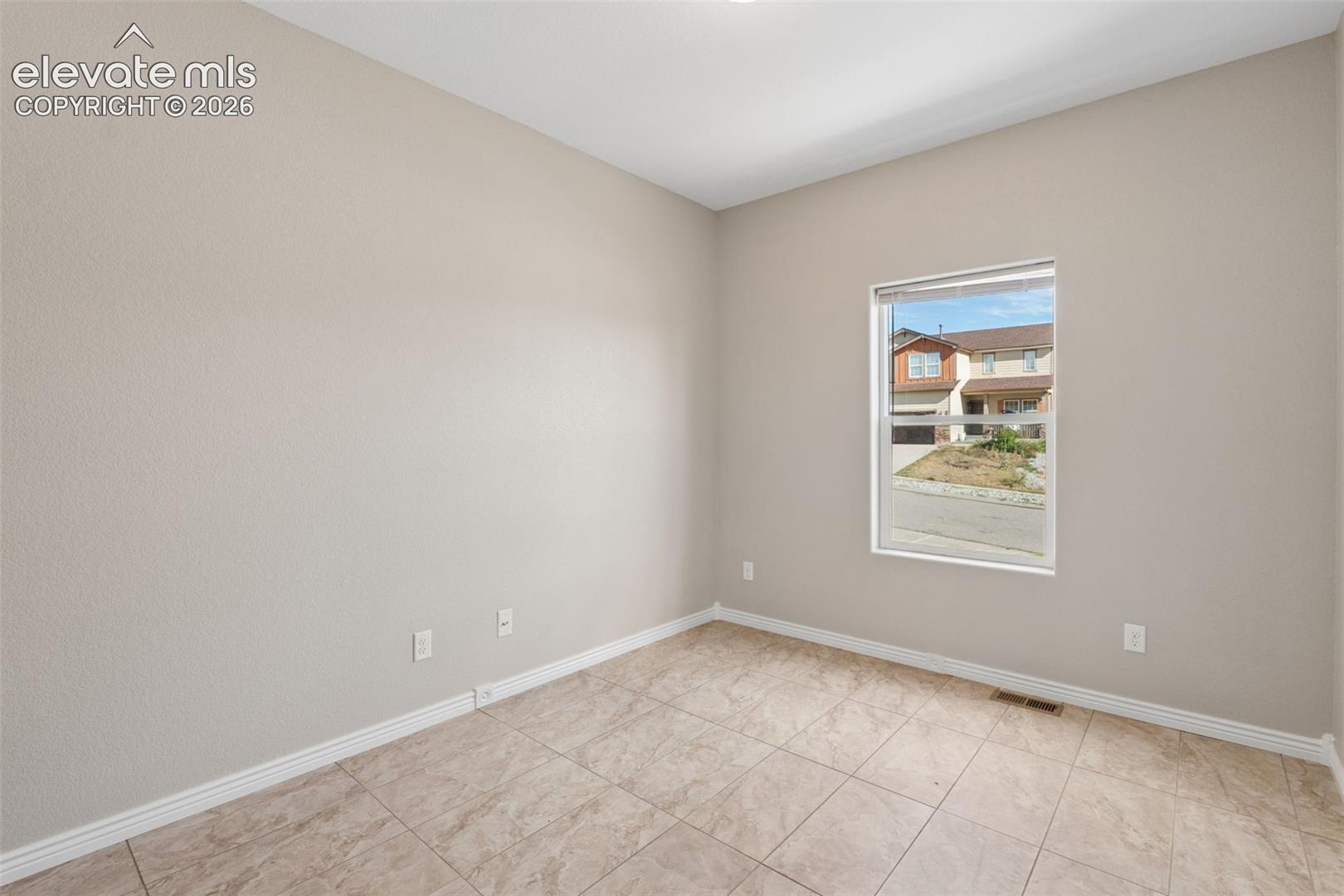 Interior room featuring neutral wall color, white trim, and tiled flooring