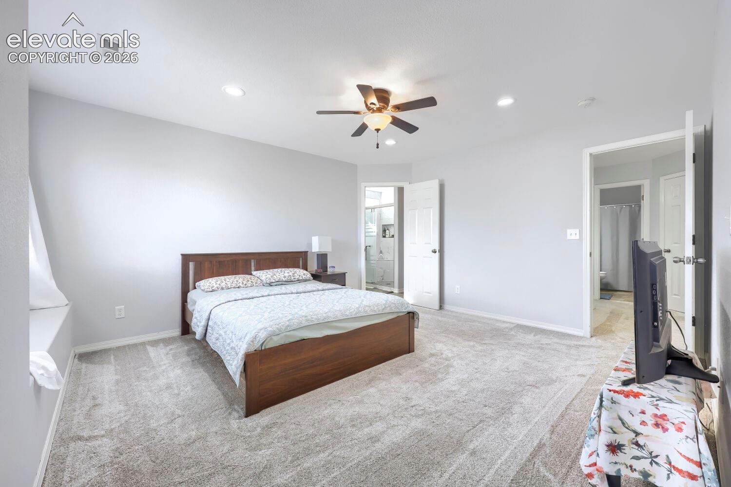Neutral-toned interior space featuring recessed lighting, a ceiling fan with integrated light fixture, wall-to-wall carpeting, and multiple entryways