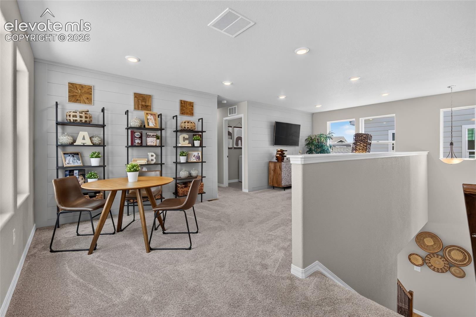 Open-concept area featuring horizontal plank wall detailing, wall-to-wall carpeting, recessed lighting, and multiple windows