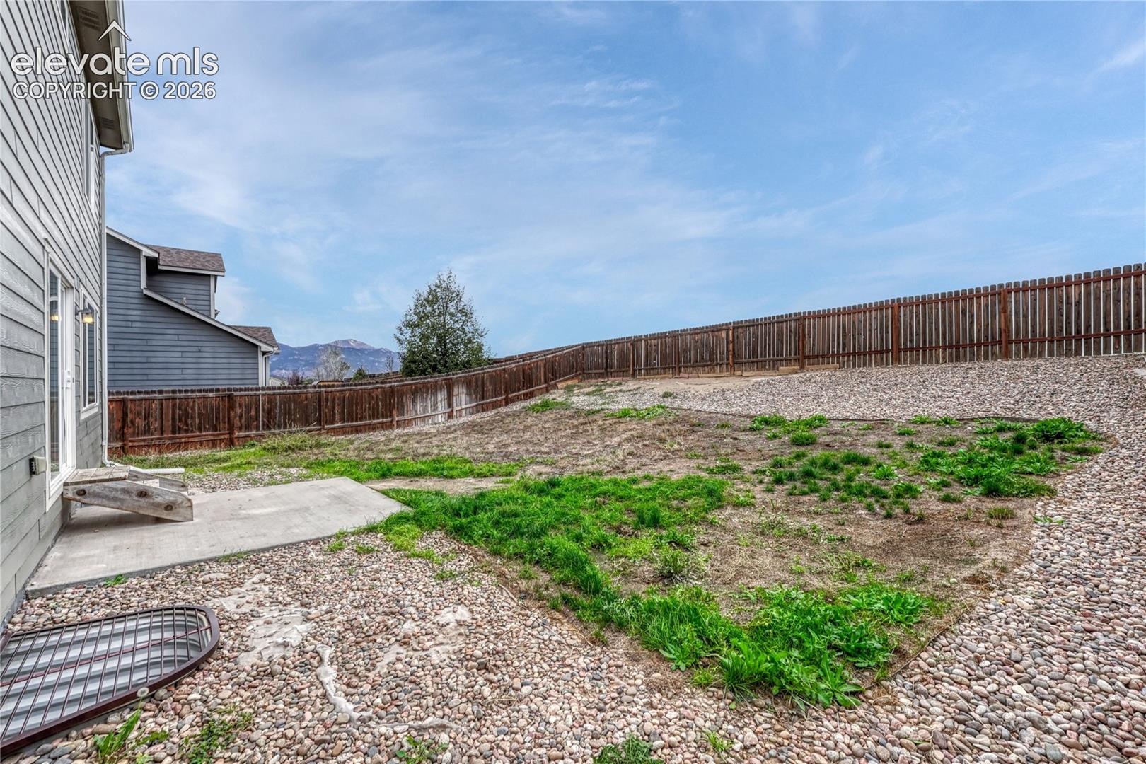 Fenced backyard and Pikes Peak view. 
