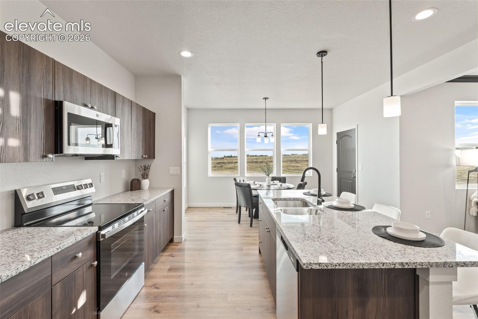 Kitchen featuring wood-finish cabinetry, stainless steel appliances, and light-toned countertops