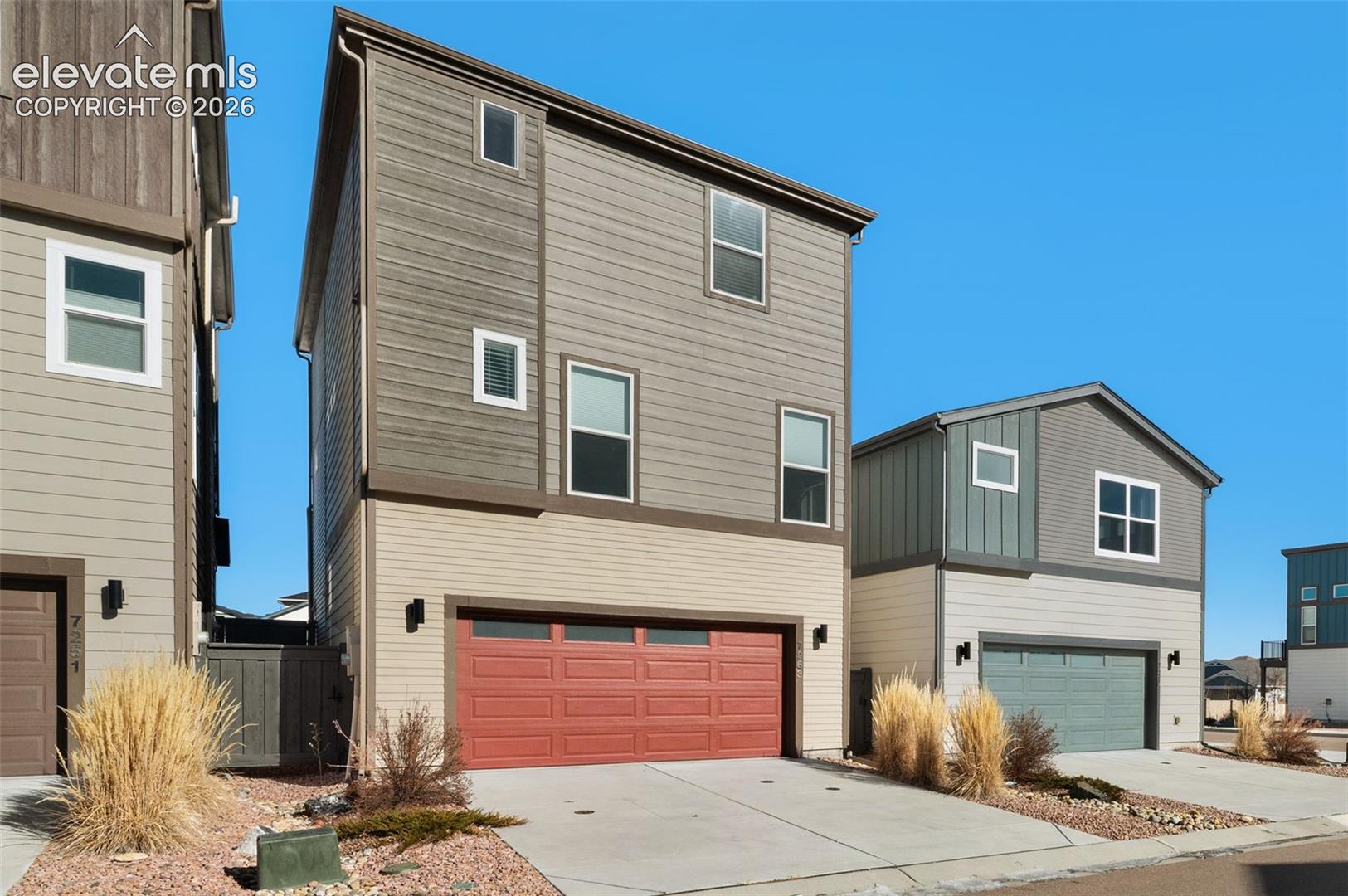 Contemporary exterior with multi-toned siding and a red garage door