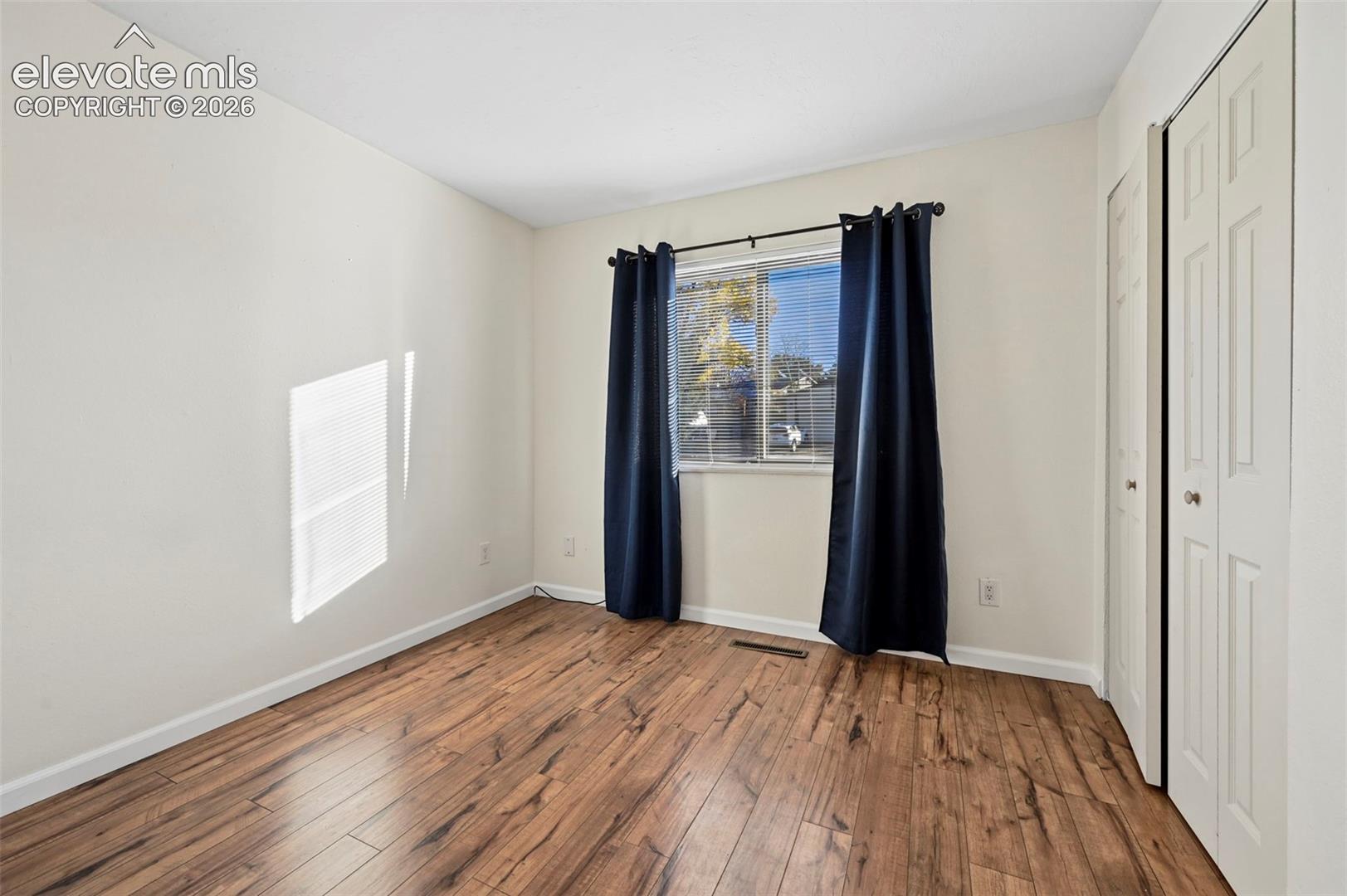 Unstaged secondary bedroom on main floor with LVP floors