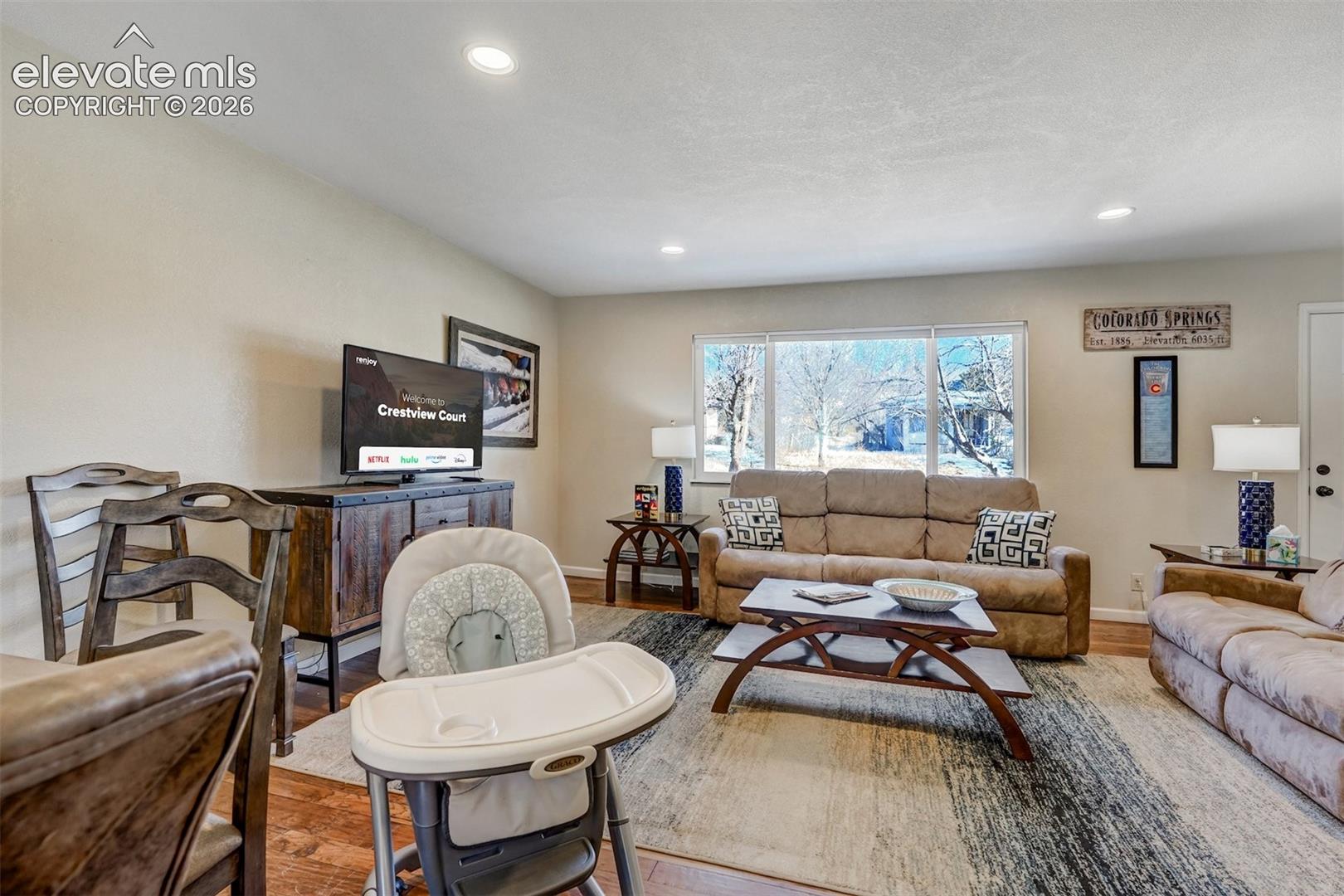 Recessed ceiling lighting, wood-finish flooring, and expansive windows