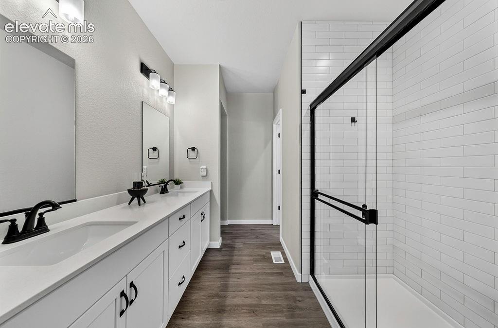 Double vanity with white countertops, matte black faucets, and rectangular undermount sinks