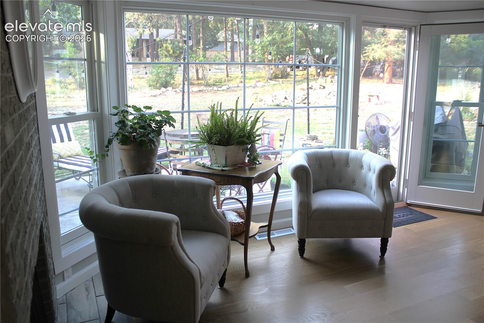 Hardwood flooring, expansive window, transom window, glass-paneled door, brick fireplace surround