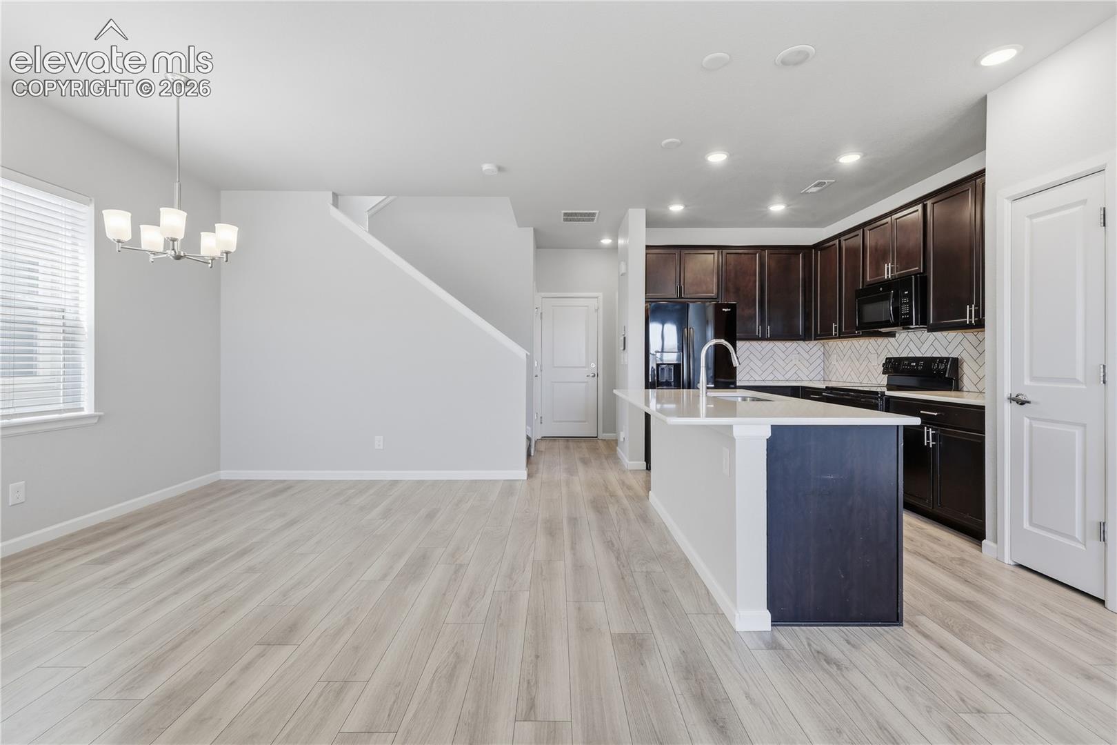 Open-concept living area with light wood-finish flooring