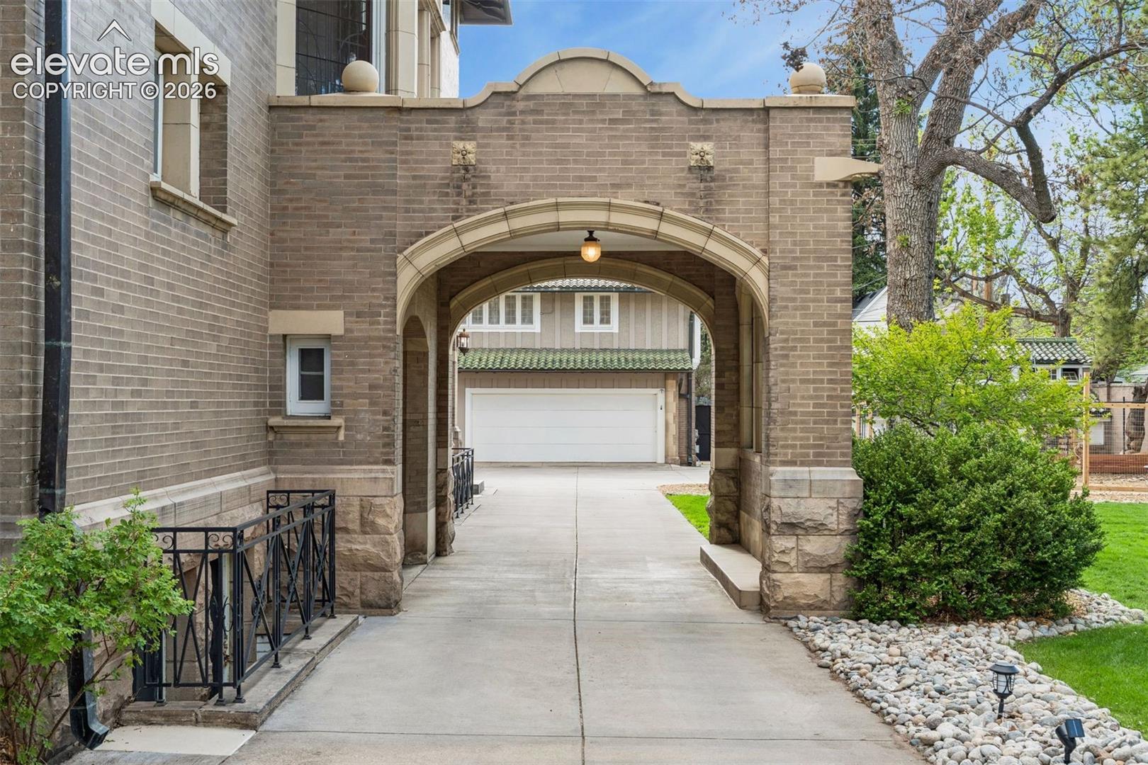 Grand portico leading to carriage house and garage. Heated driveway.