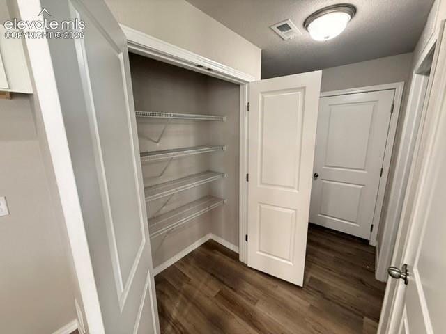 Closet with wire shelving, wood-finish flooring, and white trim
