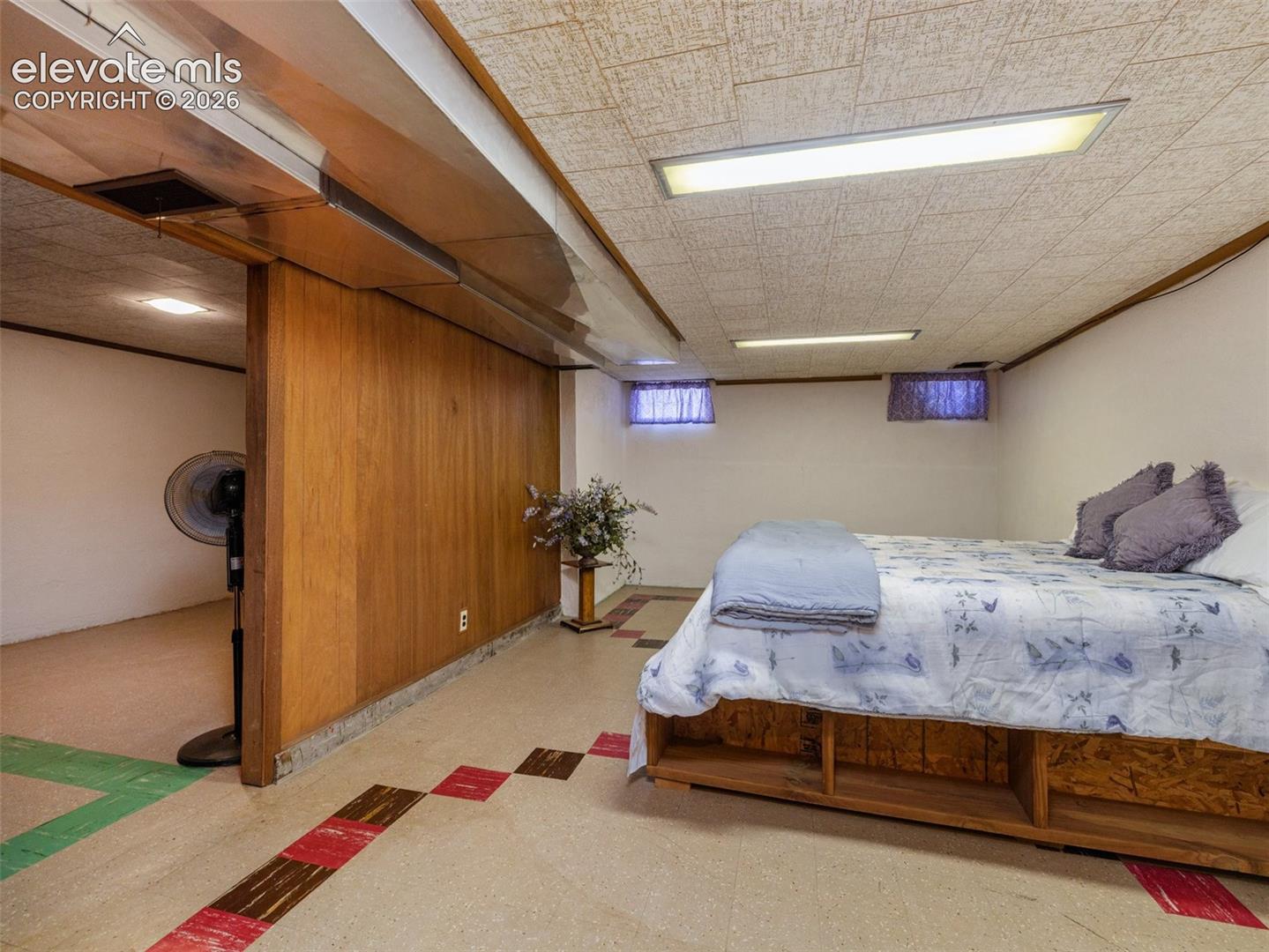 Finished room featuring wood-paneling, inset rectangular lighting, tile flooring, and horizontal sliding windows