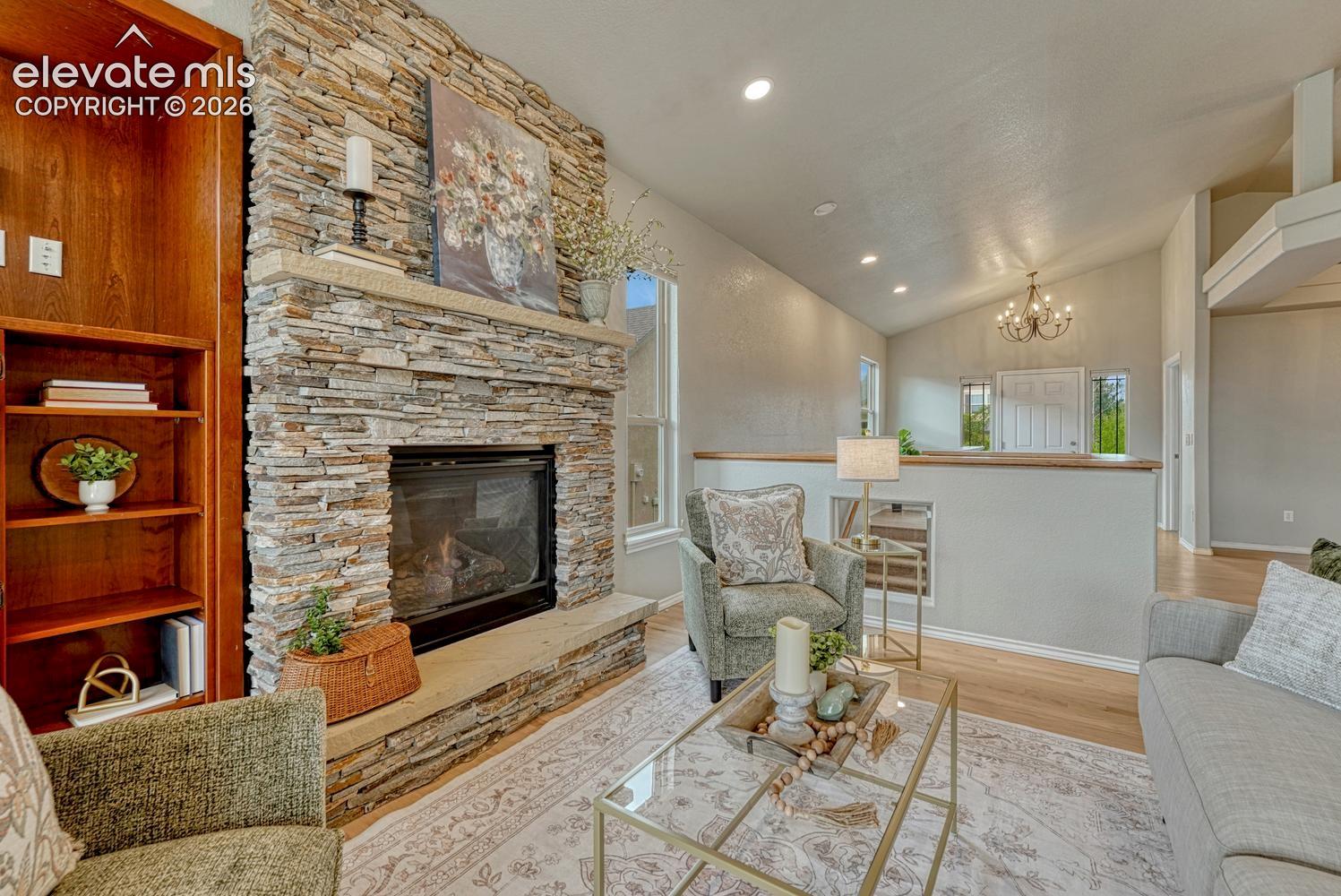 Gorgeous gas fireplace in the Great Room with floor to ceiling stone surround, raised hearth, and built-in bookshelves.