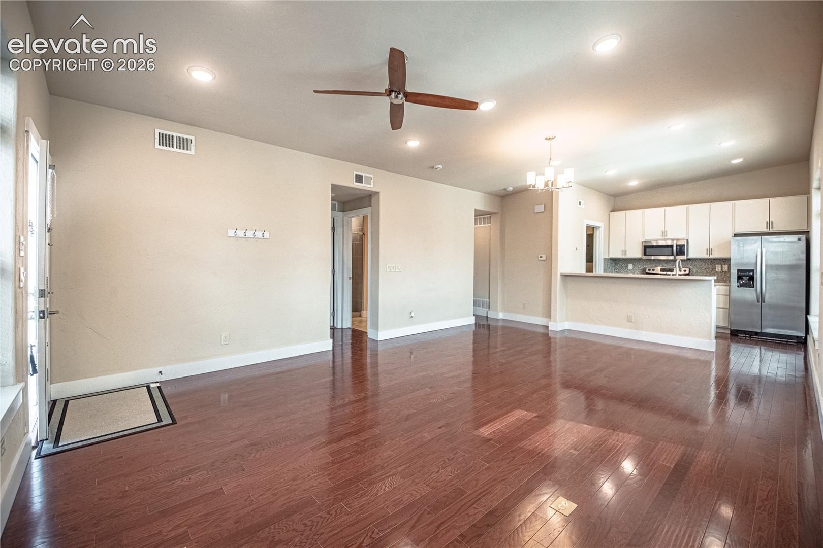 Open-concept living space featuring wood-finish flooring, recessed lighting, and a ceiling fan
