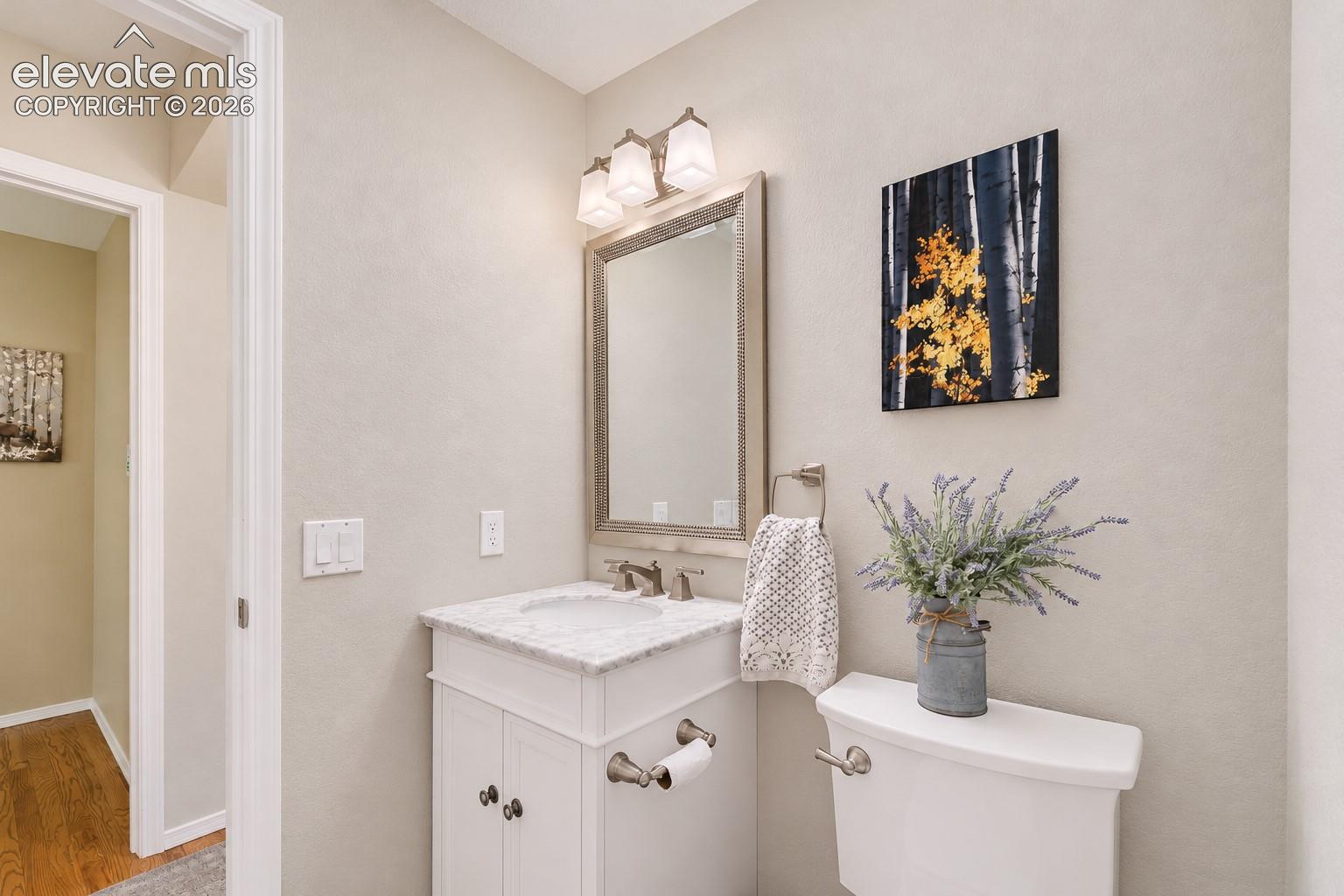 Main Level Powder Bathroom with vanity and framed mirror.