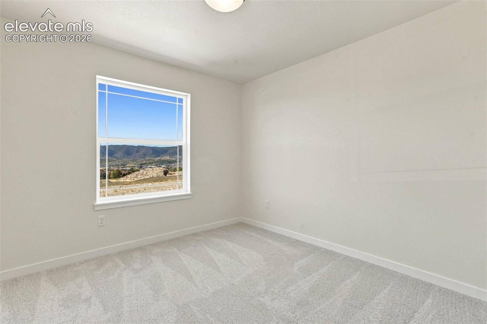 Bedroom 3 features with soft white walls and plush gray carpeting