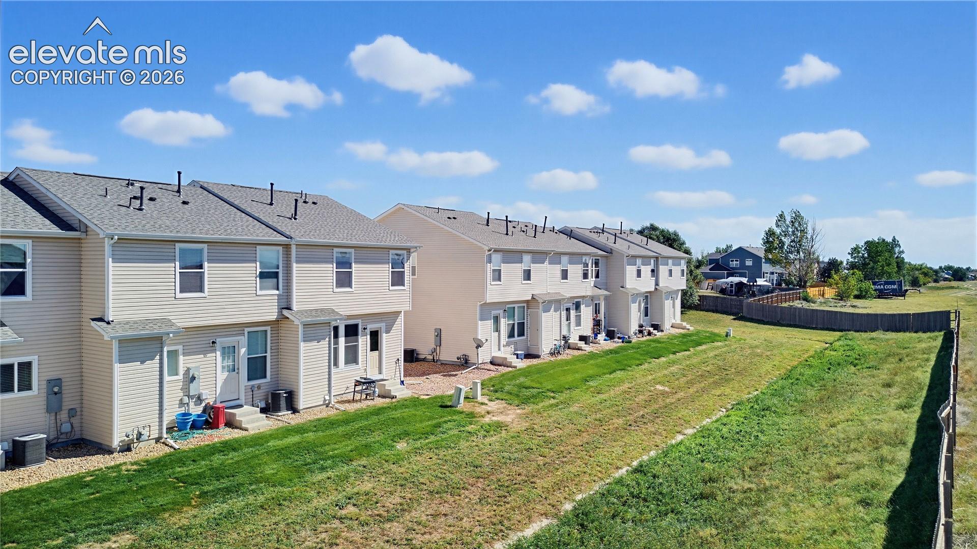 Townhome exteriors feature light-colored siding and grey shingle roofing