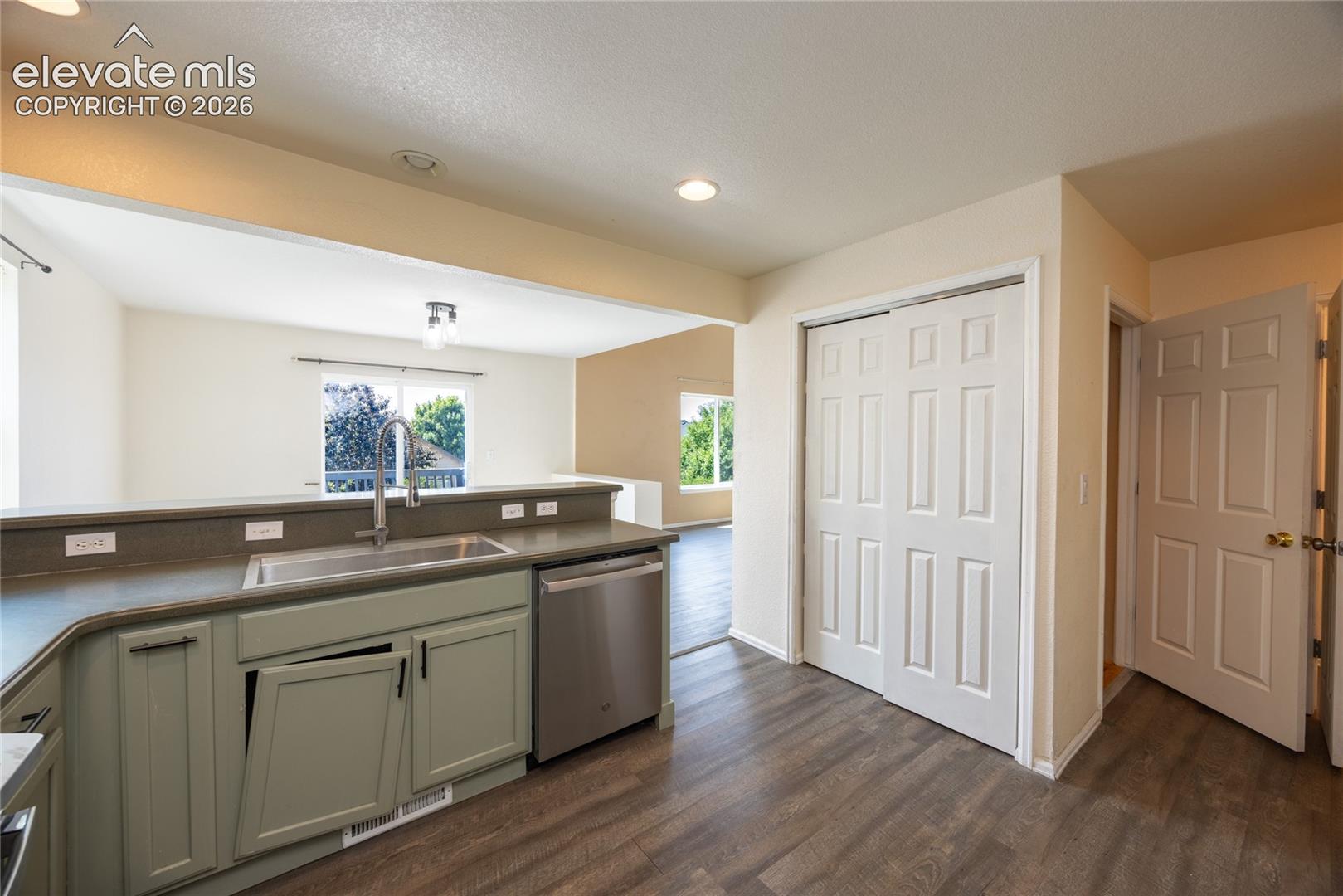 Kitchen featuring wood-finish flooring, recessed lighting, stainless steel sink with a gooseneck faucet, and a stainless steel dishwasher