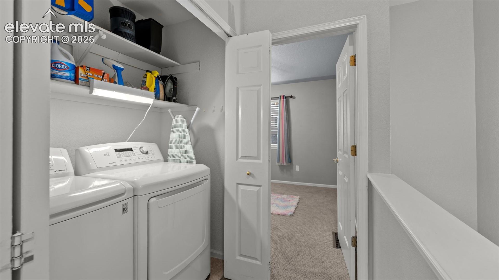 Laundry closet featuring bi-fold doors, white appliance hookups, and overhead built-in shelving