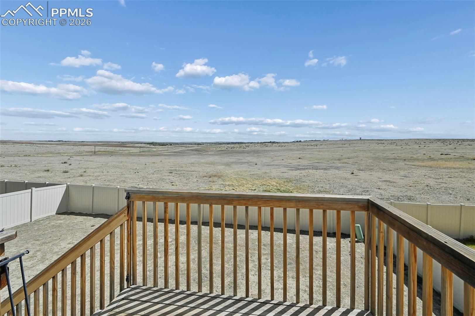 Elevated wood deck with natural wood railing overlooking a private, fenced yard
