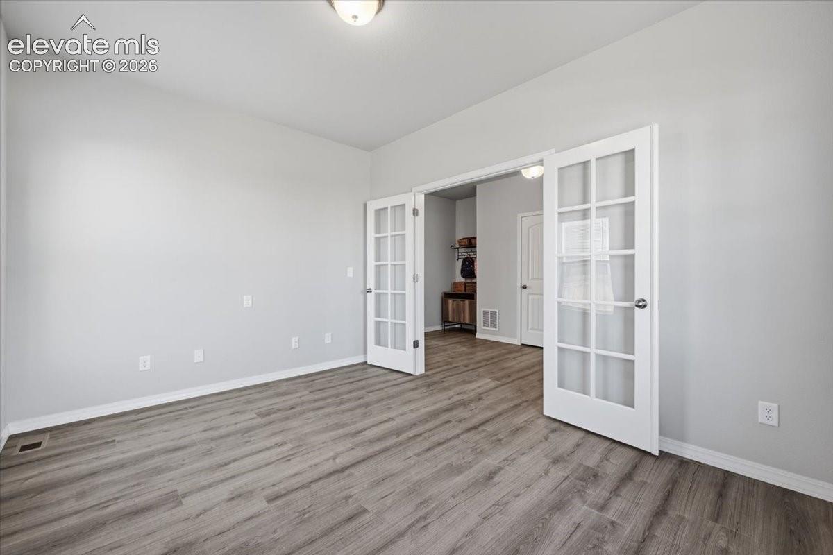 Office featuring wood-finish flooring and white interior doors with glass panes