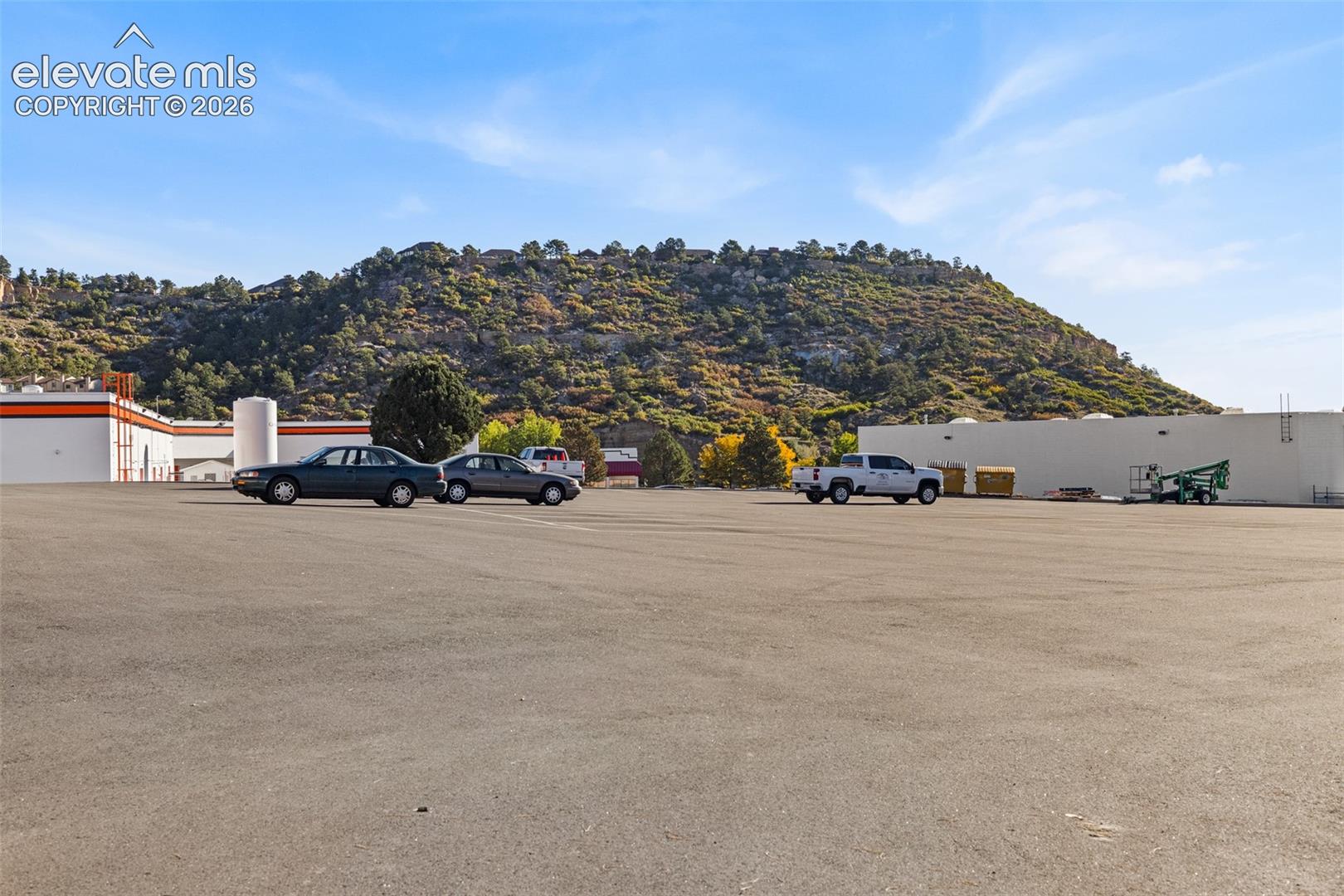 Expansive asphalt-paved lot featuring a prominent mountain backdrop