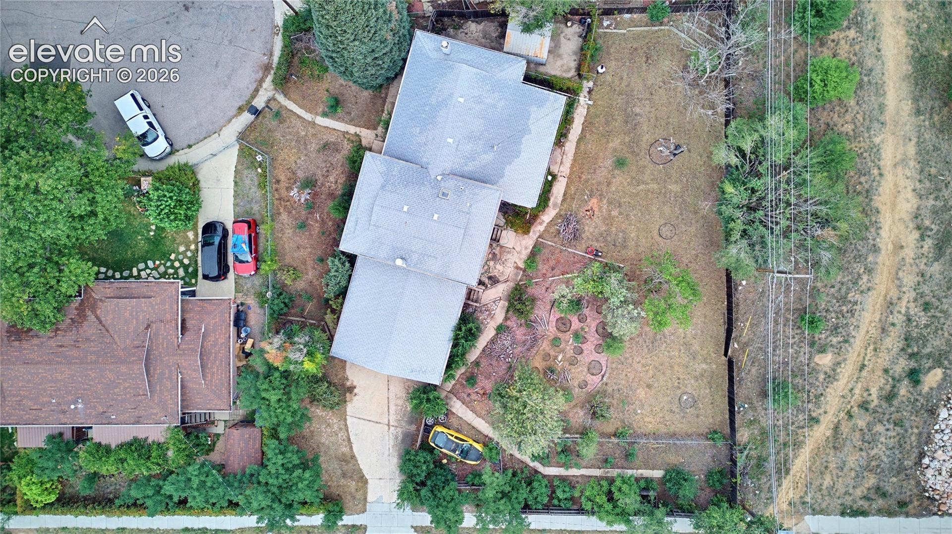 Spacious property with a light-colored shingled roof and a paved driveway