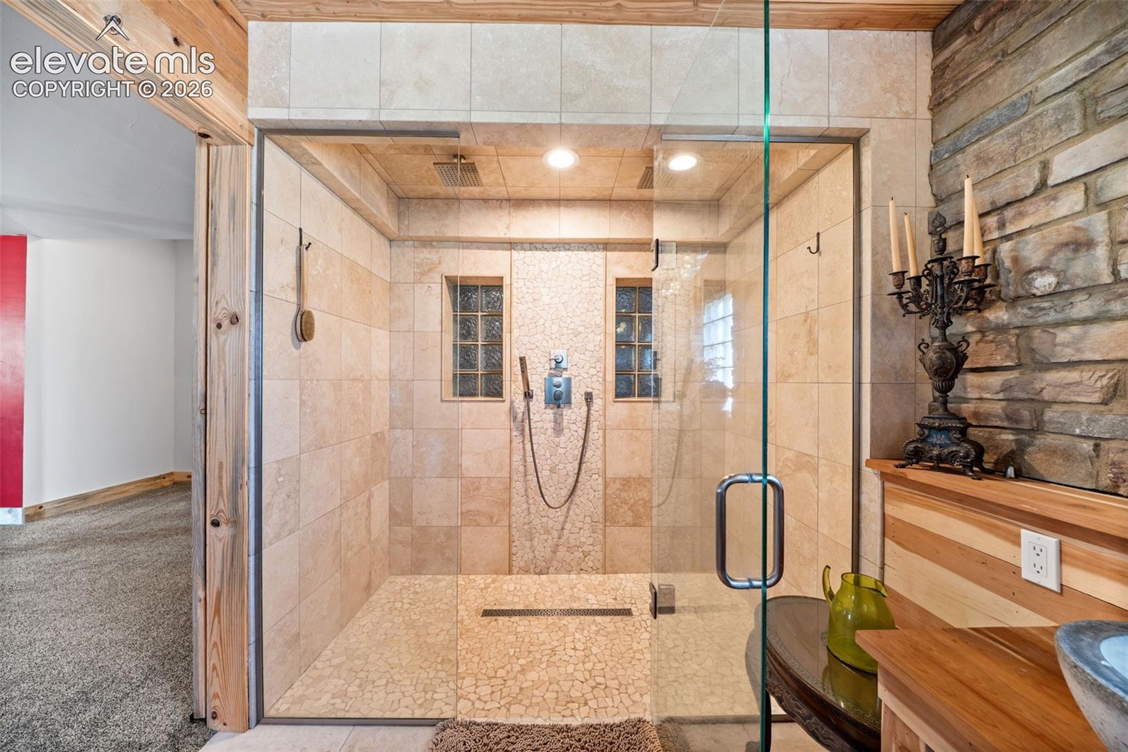 Primary en-suite with a custom tile shower and Delta fixtures.
