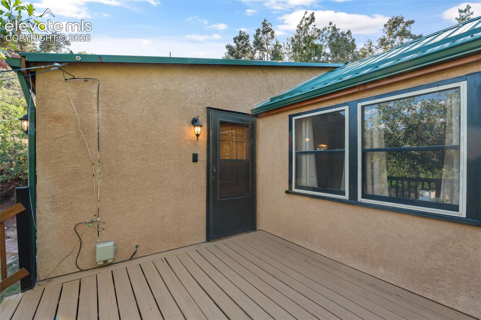 Outdoor deck with wood-finish planks and stucco exterior