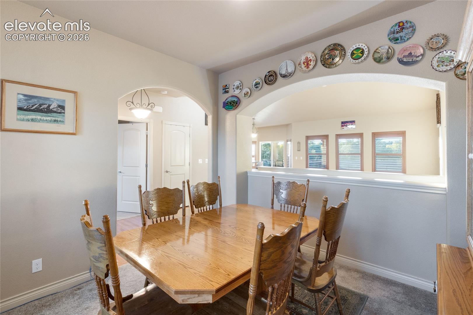 Dining area featuring a decorative arched wall niche, recessed wall opening, and arched entryways, looks into the Living Room
