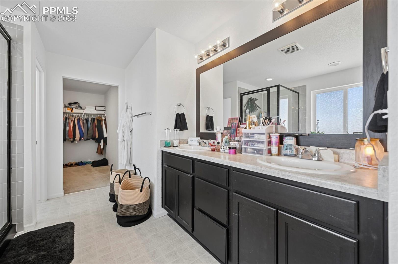 Double vanity with dark wood-finish cabinetry and light countertops
