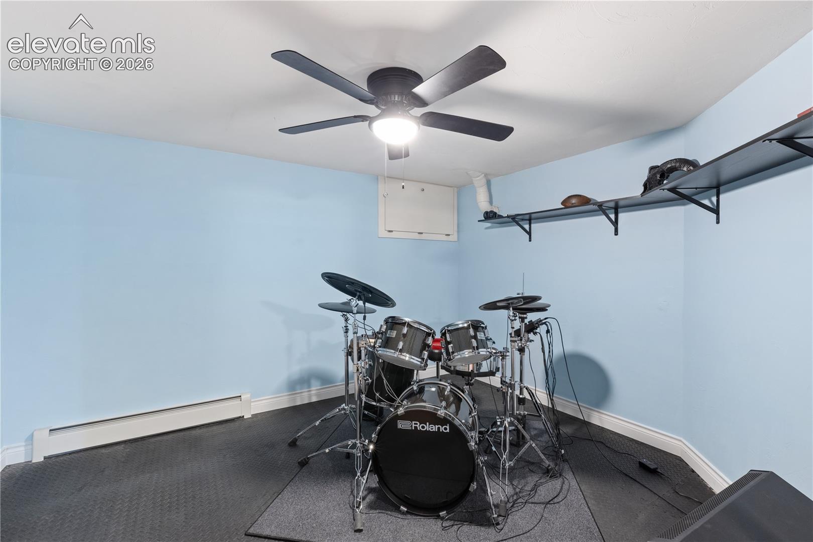 Room featuring light blue walls, white trim, and dark textured flooring