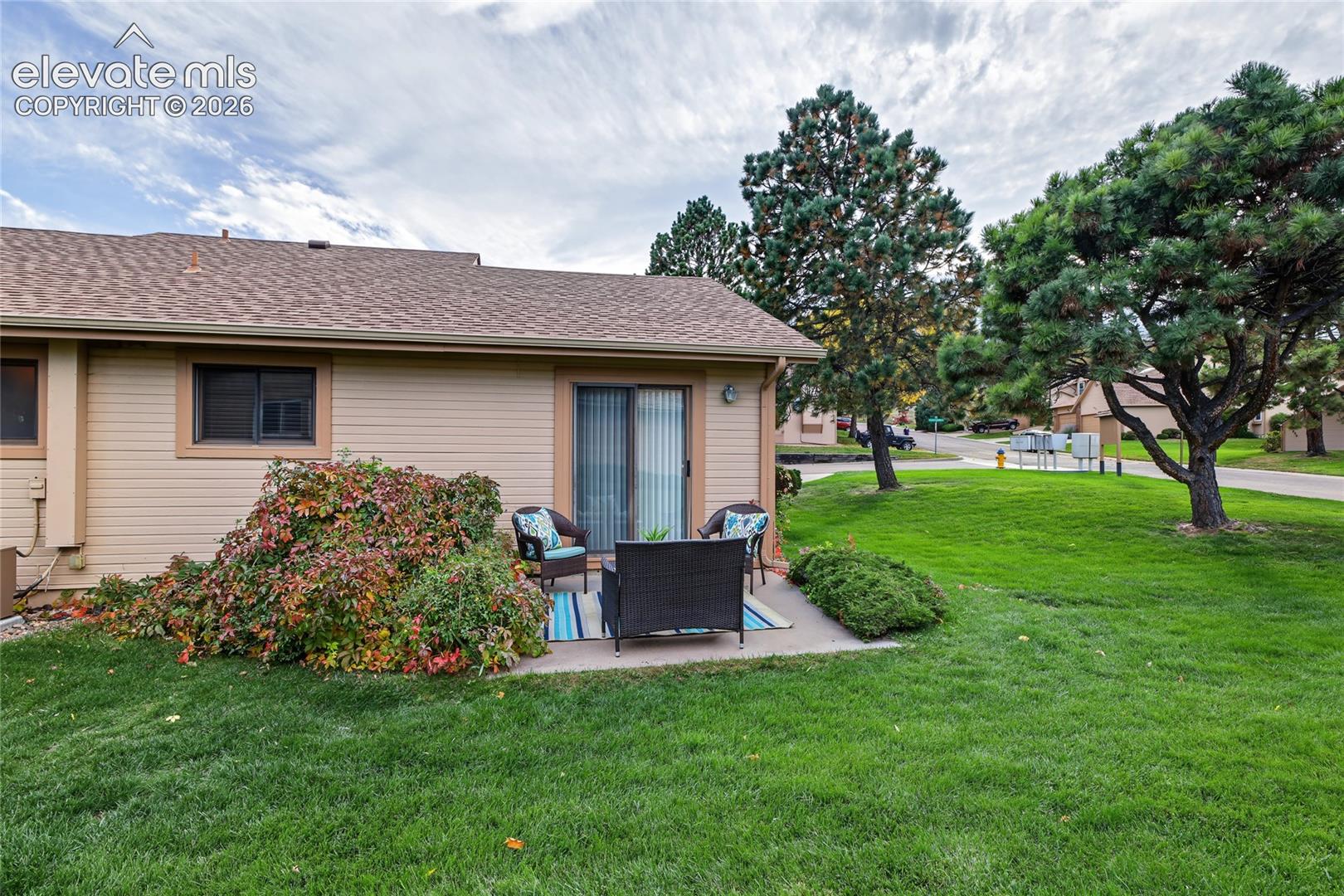 Private patio with direct access, sliding glass door, and surrounding mature landscaping