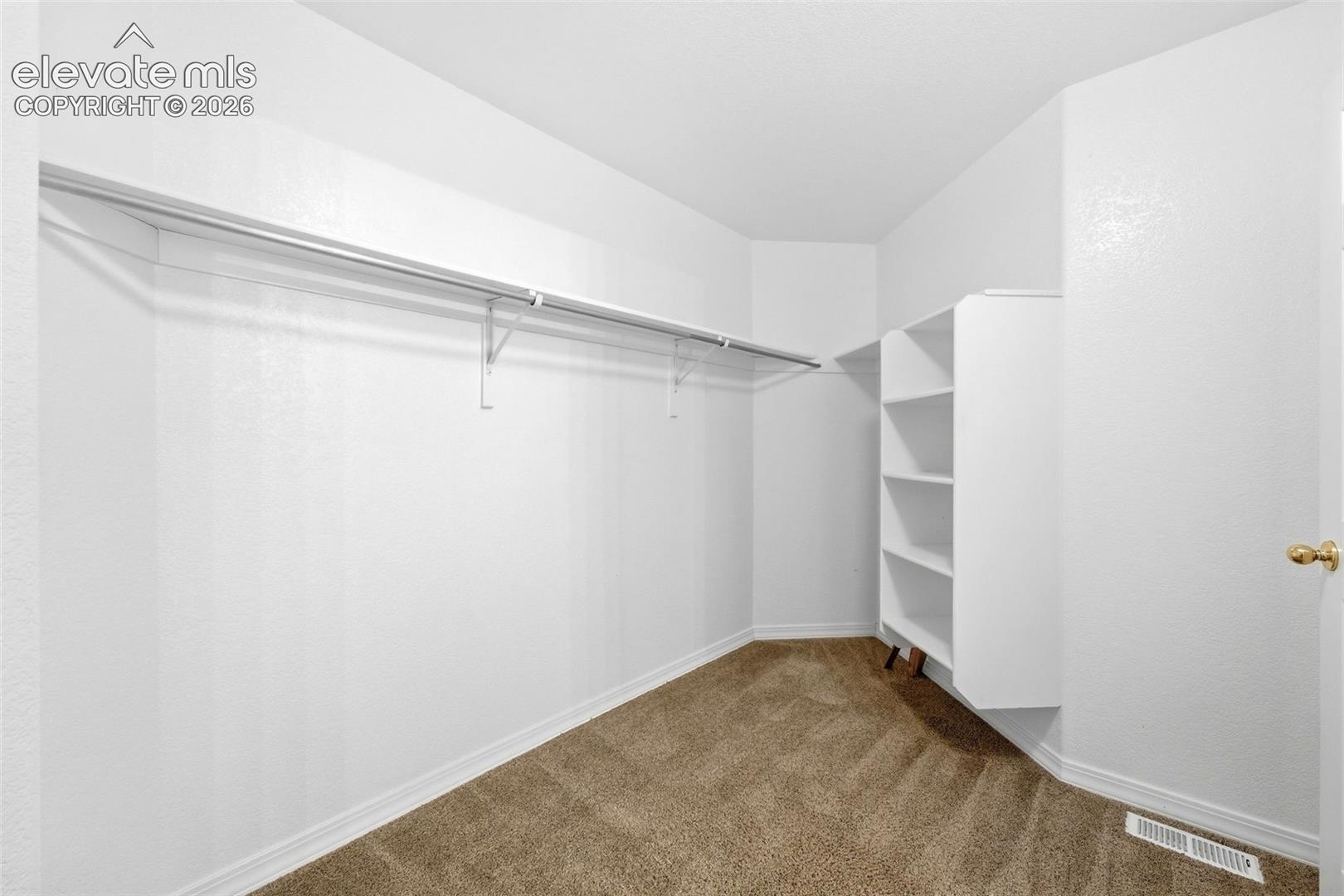 Large Primary Walk In Closet with Built In Shelving