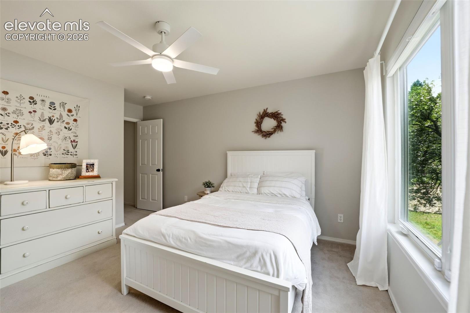Secondary upstairs bedroom with large window and walk in closet