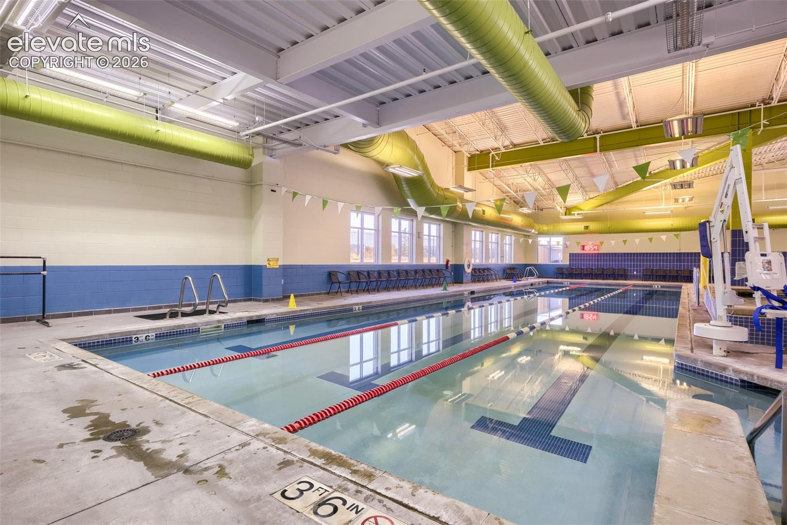 Indoor aquatic facility featuring multiple swim lanes, a lazy river, a hot tub and a kid's play area