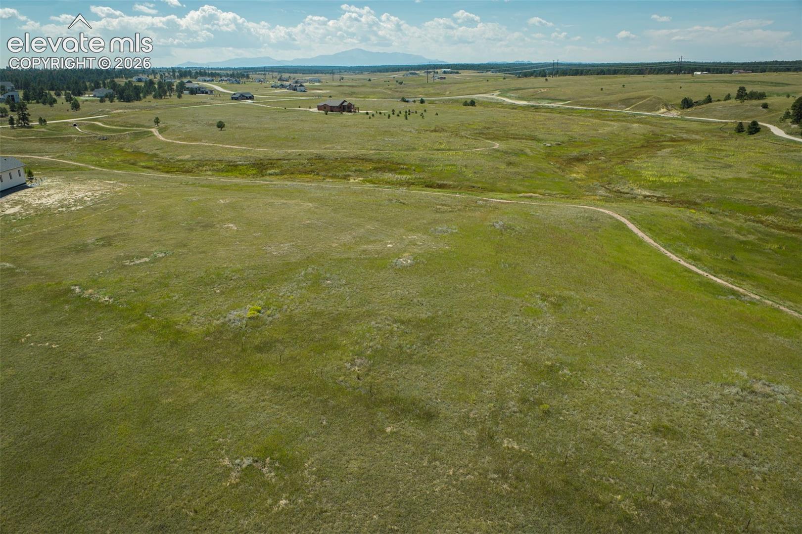 Expansive acreage featuring rolling grasslands, native terrain, and distant mountain scenery