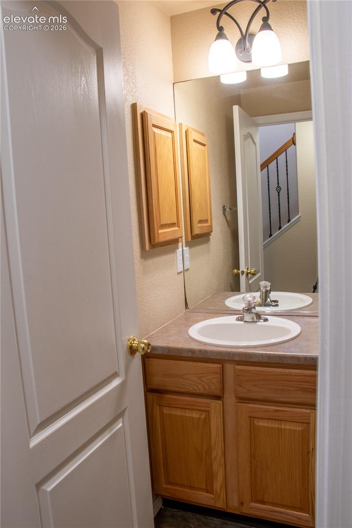 Vanity with a built-in sink, wood-finish cabinetry, and a countertop